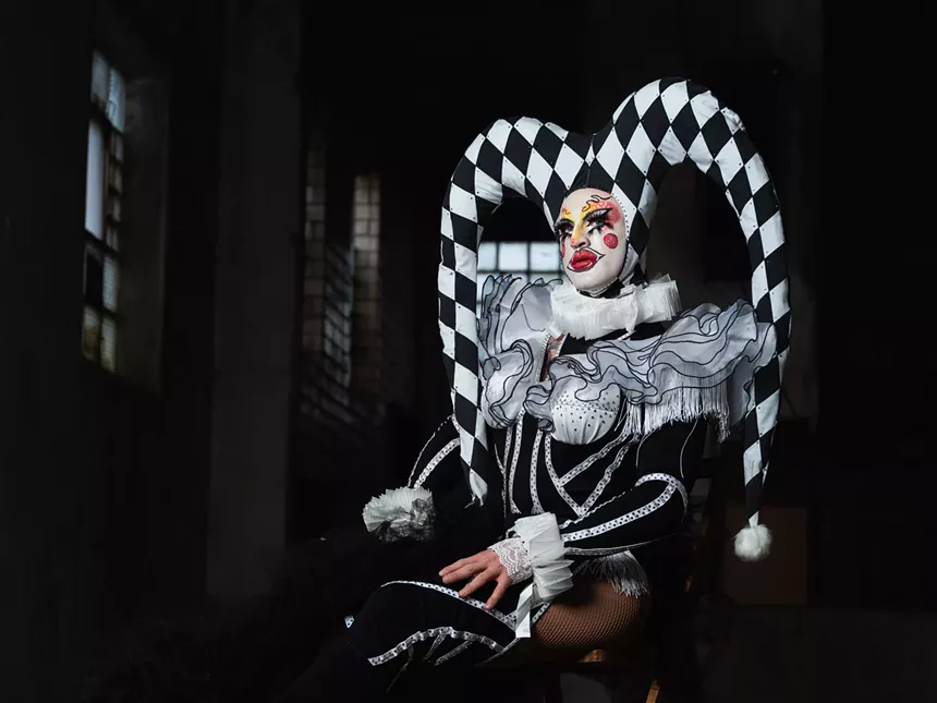 A drag performer strikes a pose in black and white.