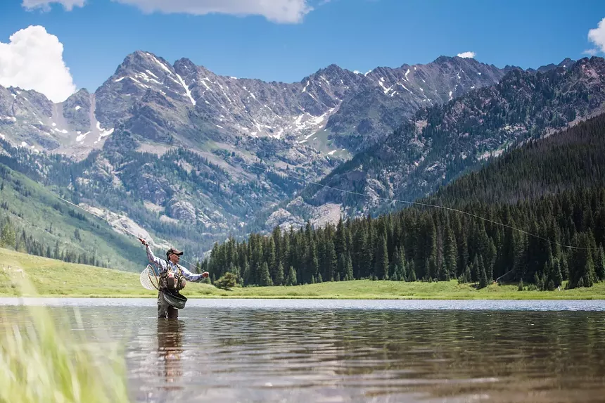 A fly fisher backdropped by the Gore Range at Piney River Ranch
