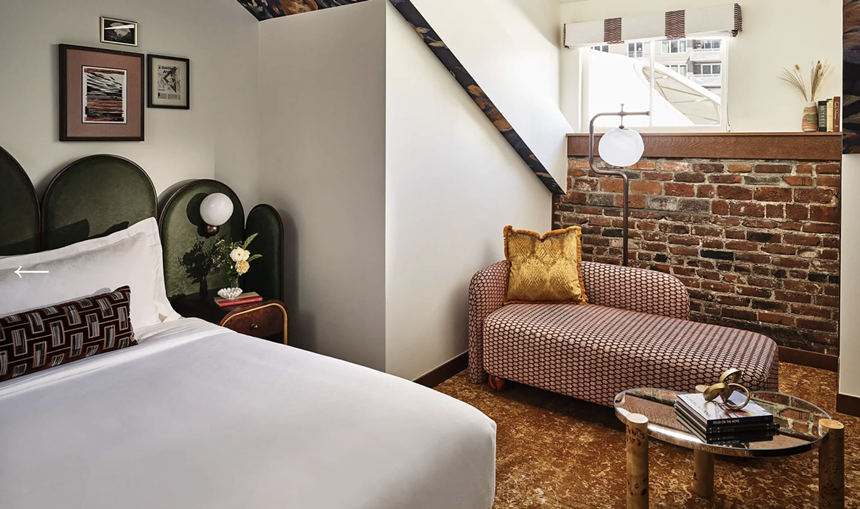 An elegant hotel room with a bed and couch