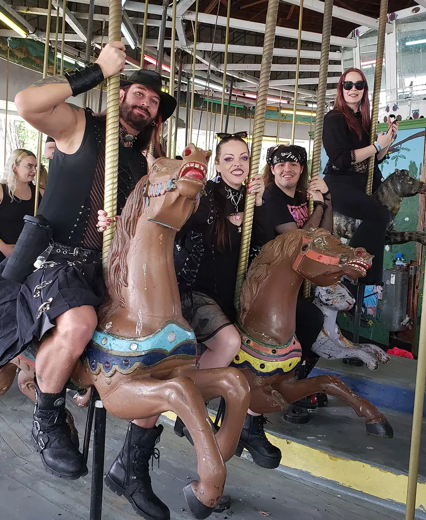 People in goth attire on a merry-go-round