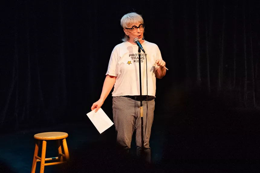 A woman talks into a microphone.