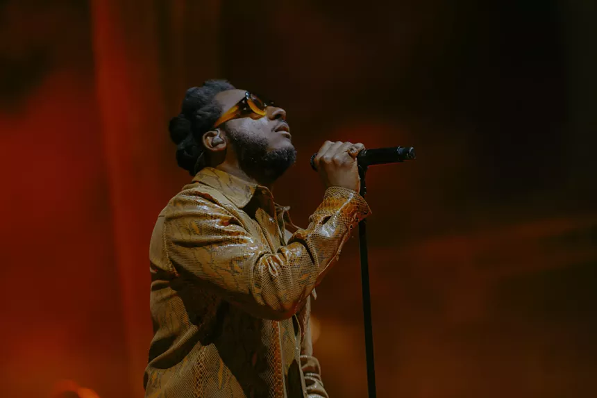 Leon Bridges on stage at Red Rocks with a red haze behind him.
