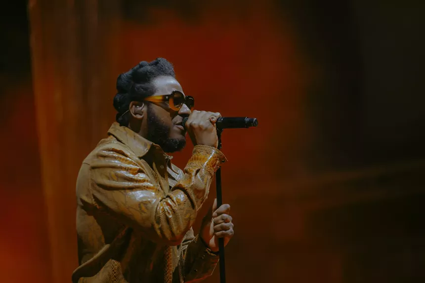 Leon Bridges on stage at Red Rocks with a red haze behind him.