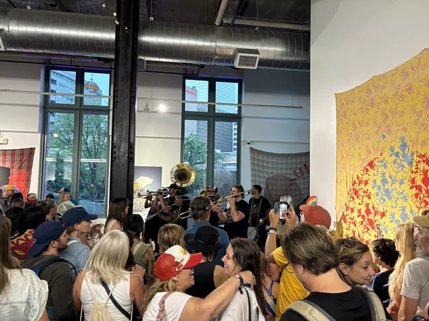 A packed room with a brass band playing