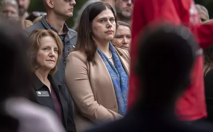 woman in blue scarf, beige jacket