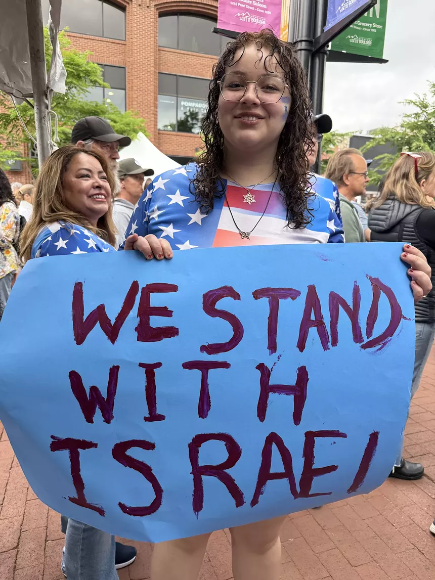 An attendee at the Boulder Jewish Festival holds a sign reading "WE STAND WITH ISRAEL"