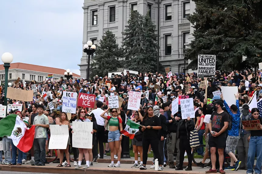 A crowd stands outside the capitol.