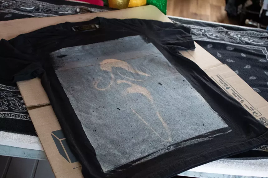 The mask from 'Scream' is printed on a black shirt.