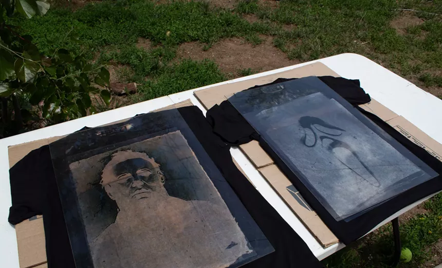 Two black shirts, one is an image of the mask from 'Scream' and another with an image of Michael Meyer from 'Halloween,' develop in the sun.
