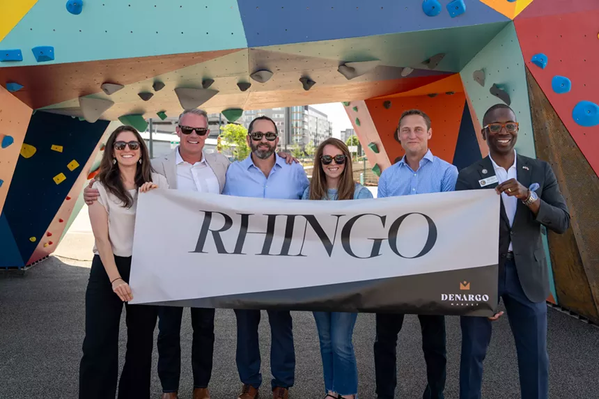 People hold up a sign that says "Rhingo"