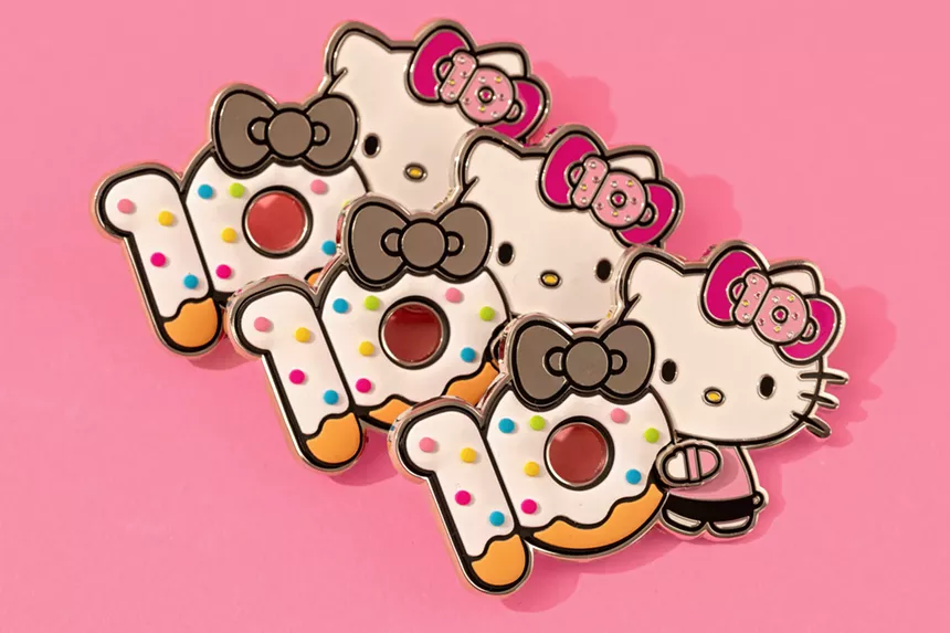 Three Hello Kitty pins with a frosted dessert that says "10th Anniversary"