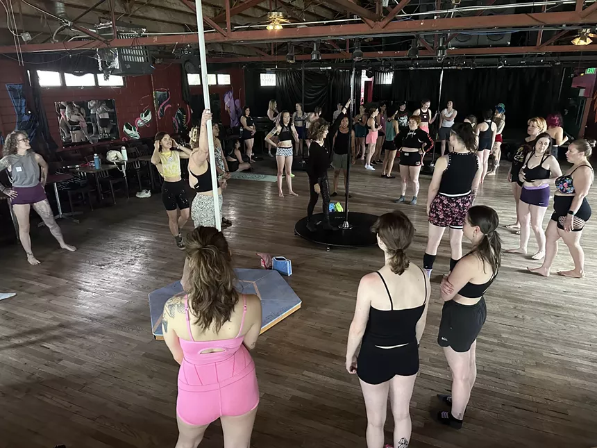 A class watches a pole instructor