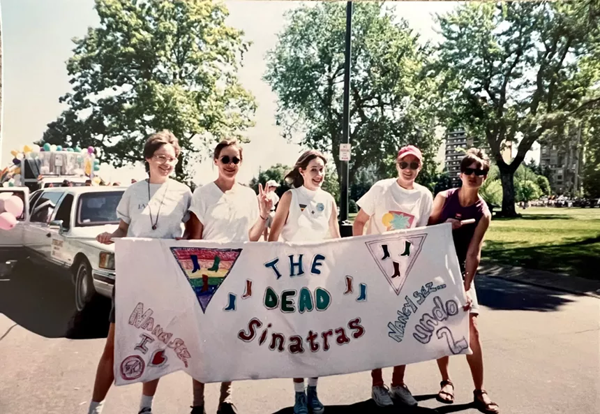 A group of woman hold a banner