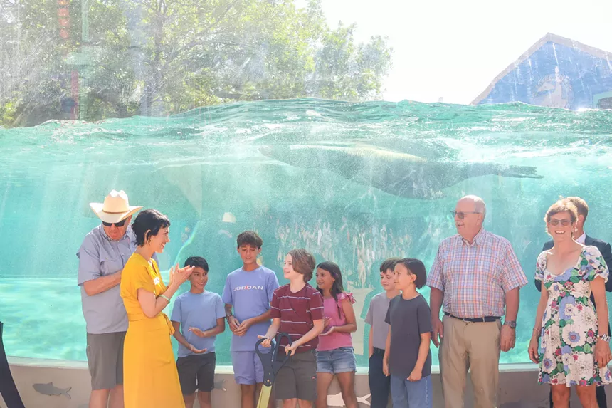People stand next to a window of water