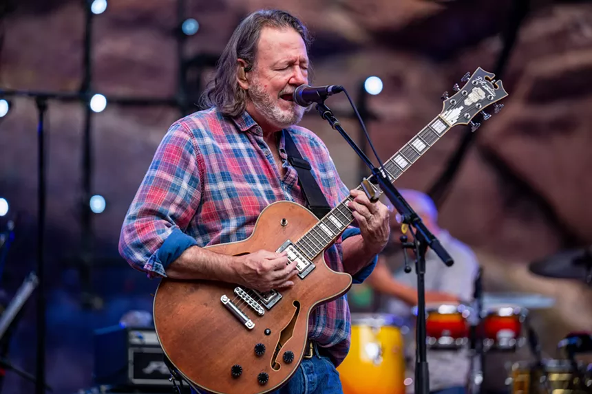John Bell singing and playing guitar