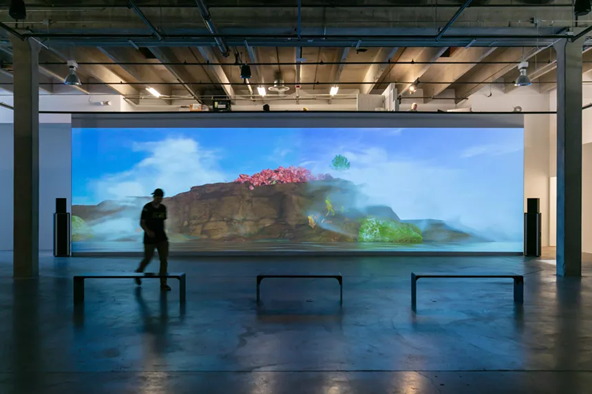 A person walks past a screen