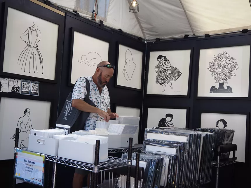 A man looks through art prints
