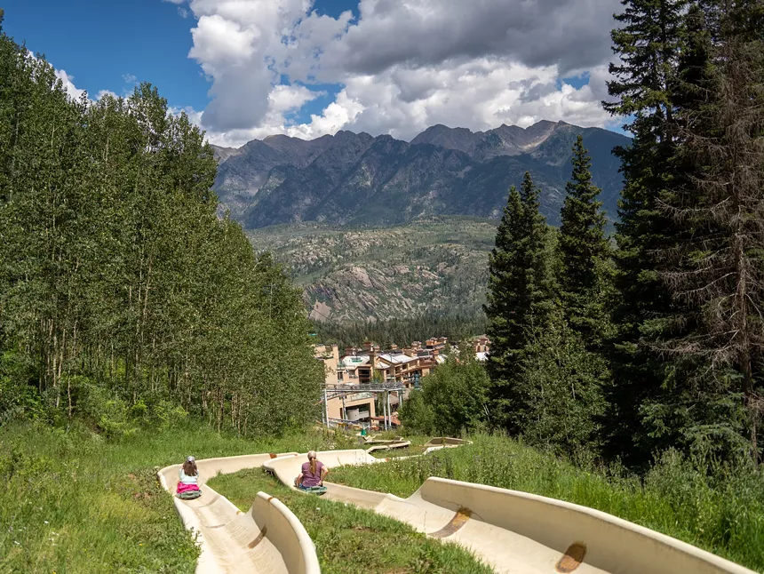 The two alpine slides at Purgatory Resort backdropped by the San Juan Mountains