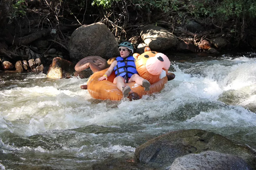 A person in a squirrel inner tube floats.