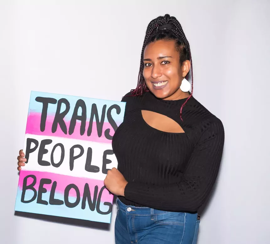 A woman holds up a sign