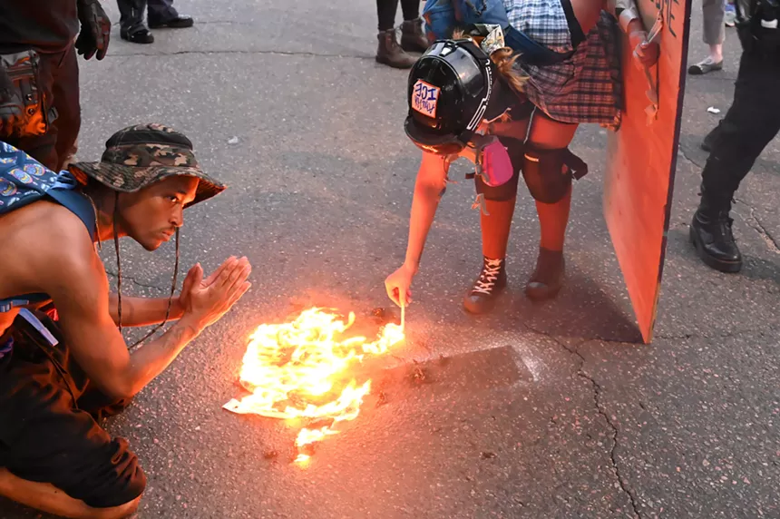 When protesters burned an American flag, one lit a cigarette.