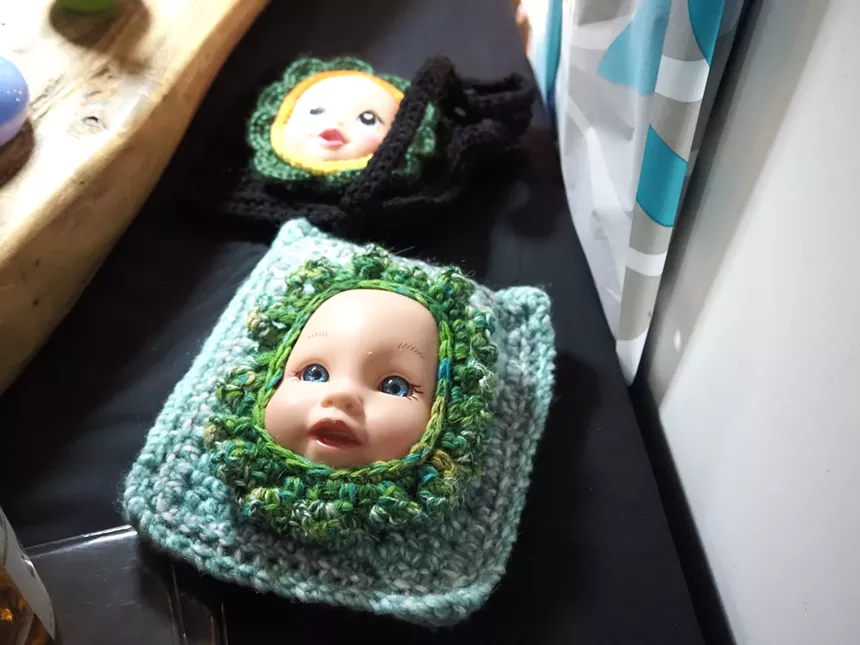 a baby doll face embedded in a crochet bag
