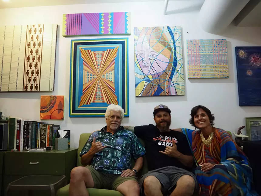 Three people sit on a couch