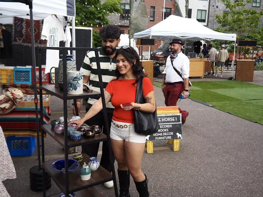 two people check out a booth of art