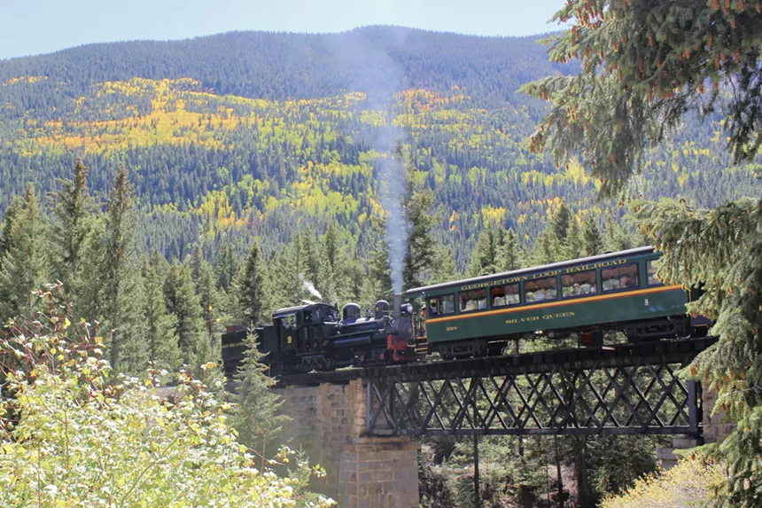 The Georgetown Loop Railroad train backdropped by mountains and autumn foliage