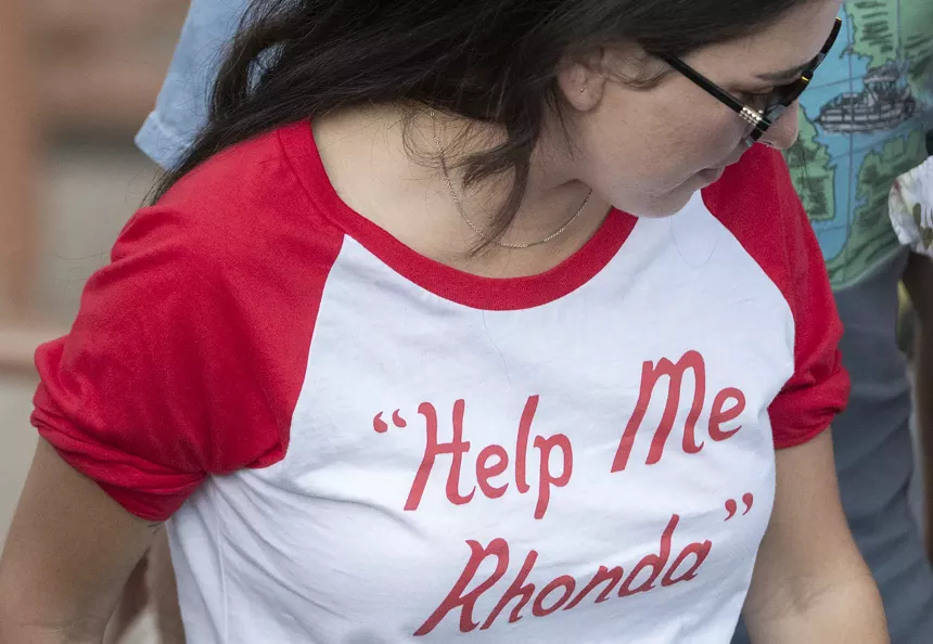 person wearing a t-shirt that reads help me rhonda