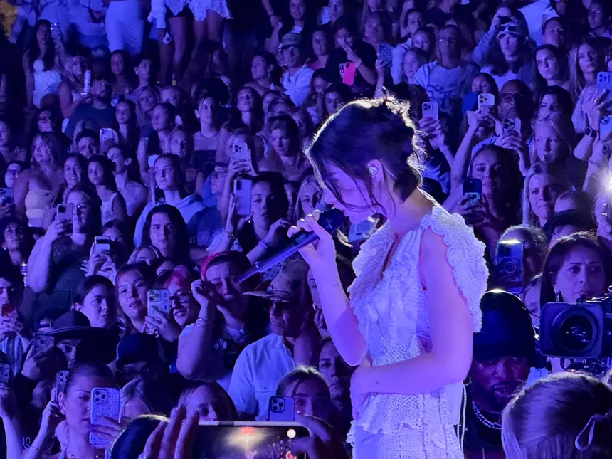 Gracie Abrams performing in the center of the Red Rocks crowd.