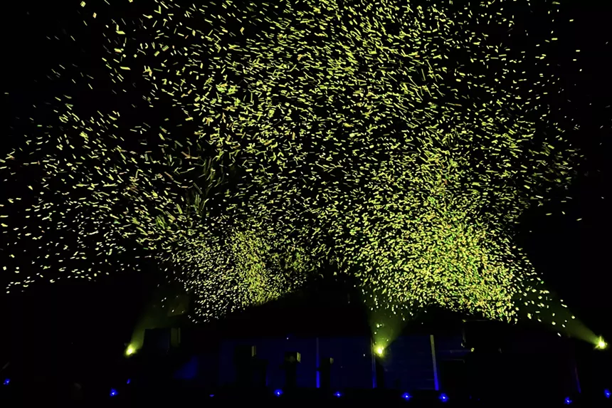 Floating bubbles glowing a yellow-green hue while backdropped by a dark sky