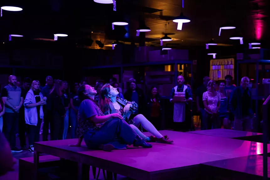 two people sit on a stage with blue and purple lighting