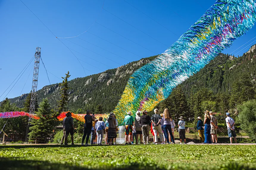 A group of people viewing Off The Beaten Path, a colorful, suspended installation at Green Box