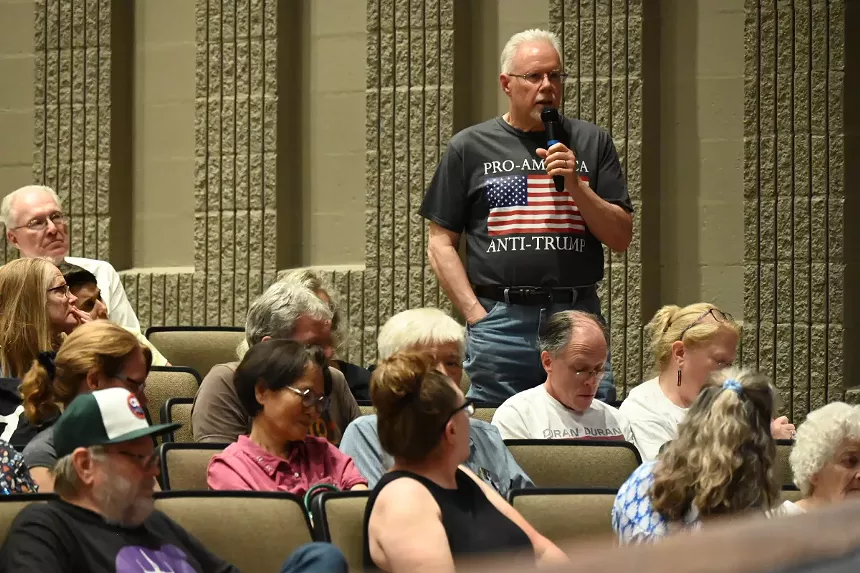 A man speaks at a town hall.