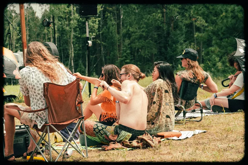 people in lawn chairs watching live music
