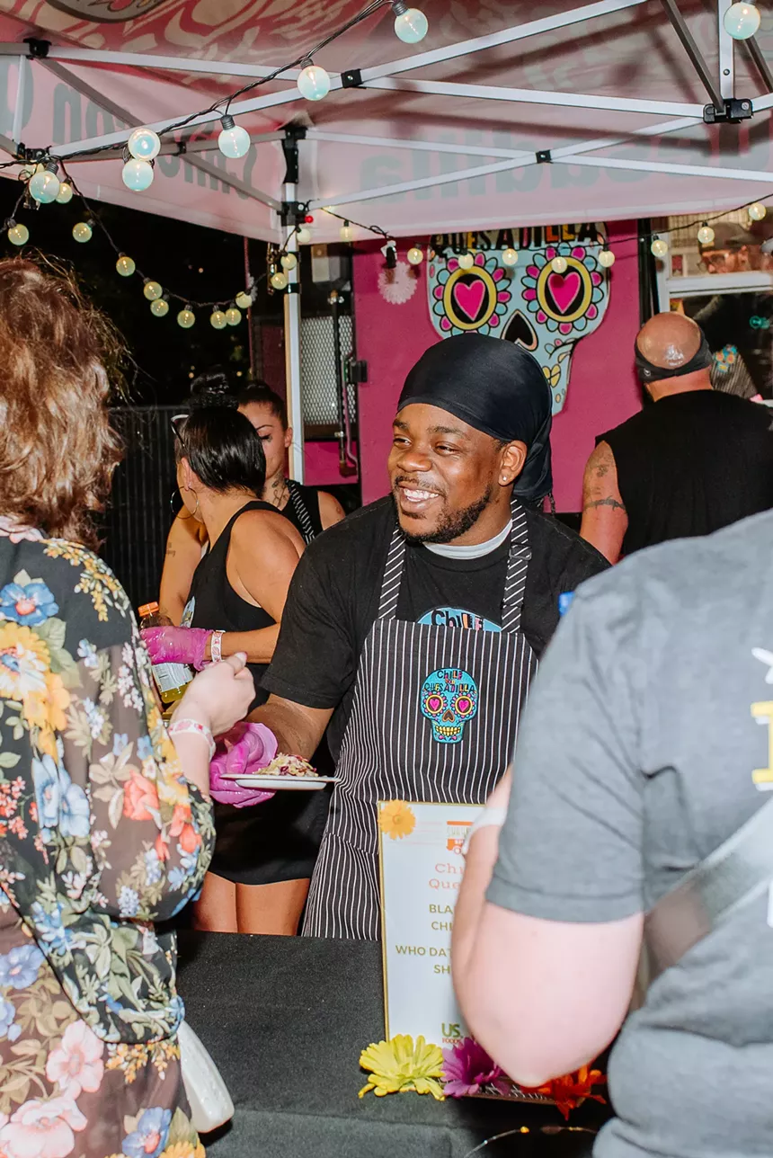 A man serving tacos at Denver Food + Wine