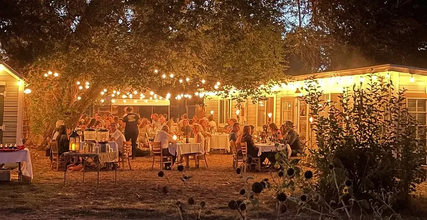 People seated at tables outside at night