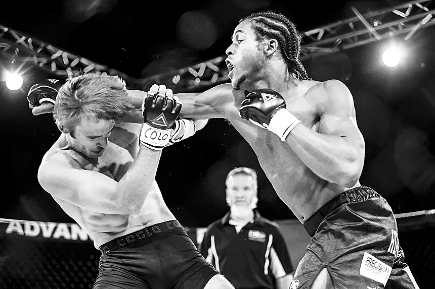 man hitting another in MMA fight.