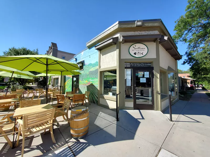 Image: front of a restaurant with green umbrellas in front