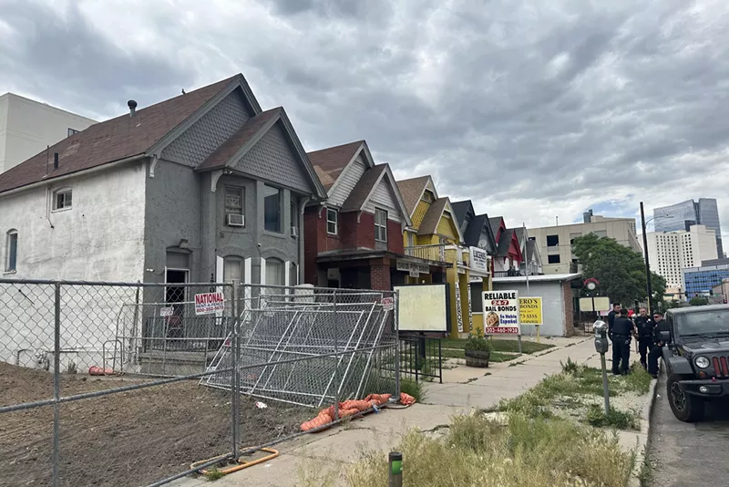 Image: Police stand outside of an abandoned home on bail bond row in Denver