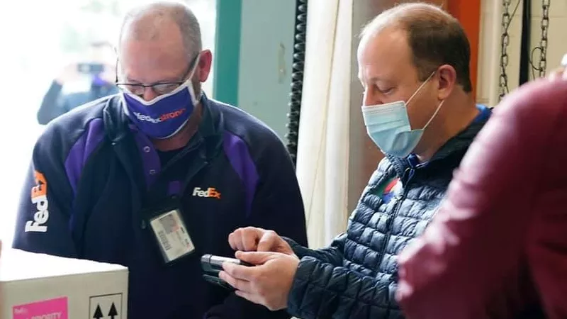 Image: Governor Jared Polis signing for the first shipment of vaccines to arrive in Colorado circa December 2020.