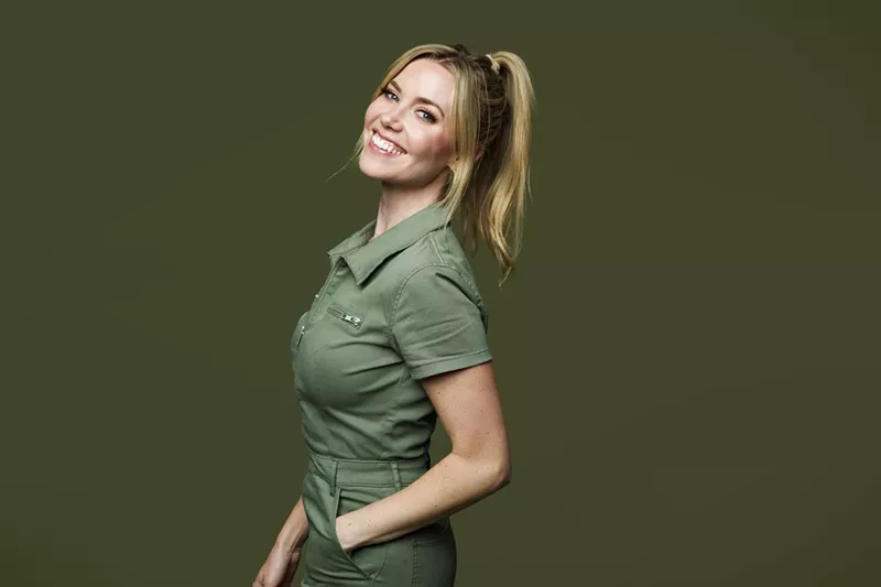 Image: woman with blonde ponytail smiling in a green polo