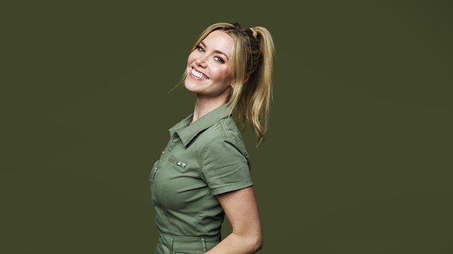 woman with blonde ponytail smiling in a green polo