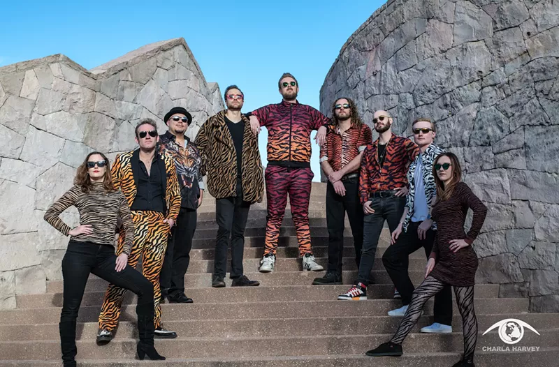 Image: bandmates wearing tiger stripes pose for a picture