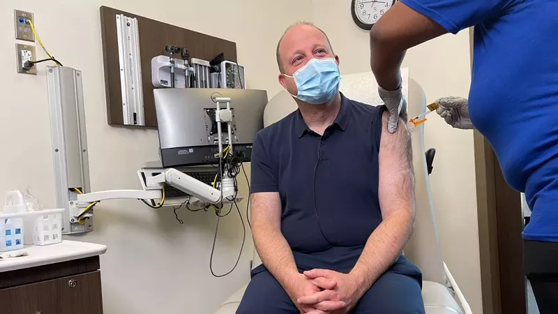 Image: Governor Jared Polis getting his booster shot last October.
