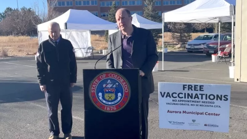 Image: Governor Jared Polis and Aurora Mayor Mike Coffman at a December 16 press conference about the fight against COVID-19 at the Aurora Municipal Center vaccination site.