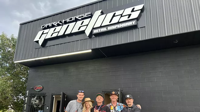 Dark Horse Genetics staff members backdropped by the dispensary's black-painted exterior
