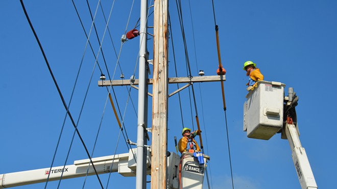 Workers up on an electric pole.