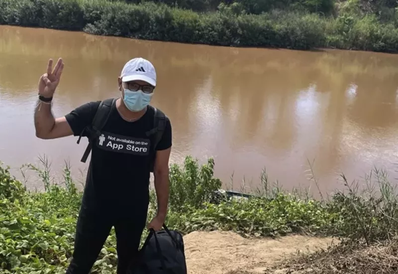 Image: Yan Soe while escaping to Thailand. The three finger salute he's holding up represents a "goodbye to someone you love."